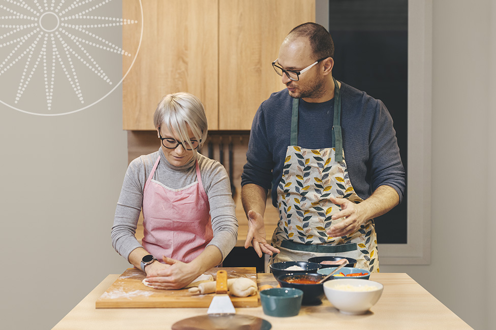 white middle aged couple making pizza in their kitchen together